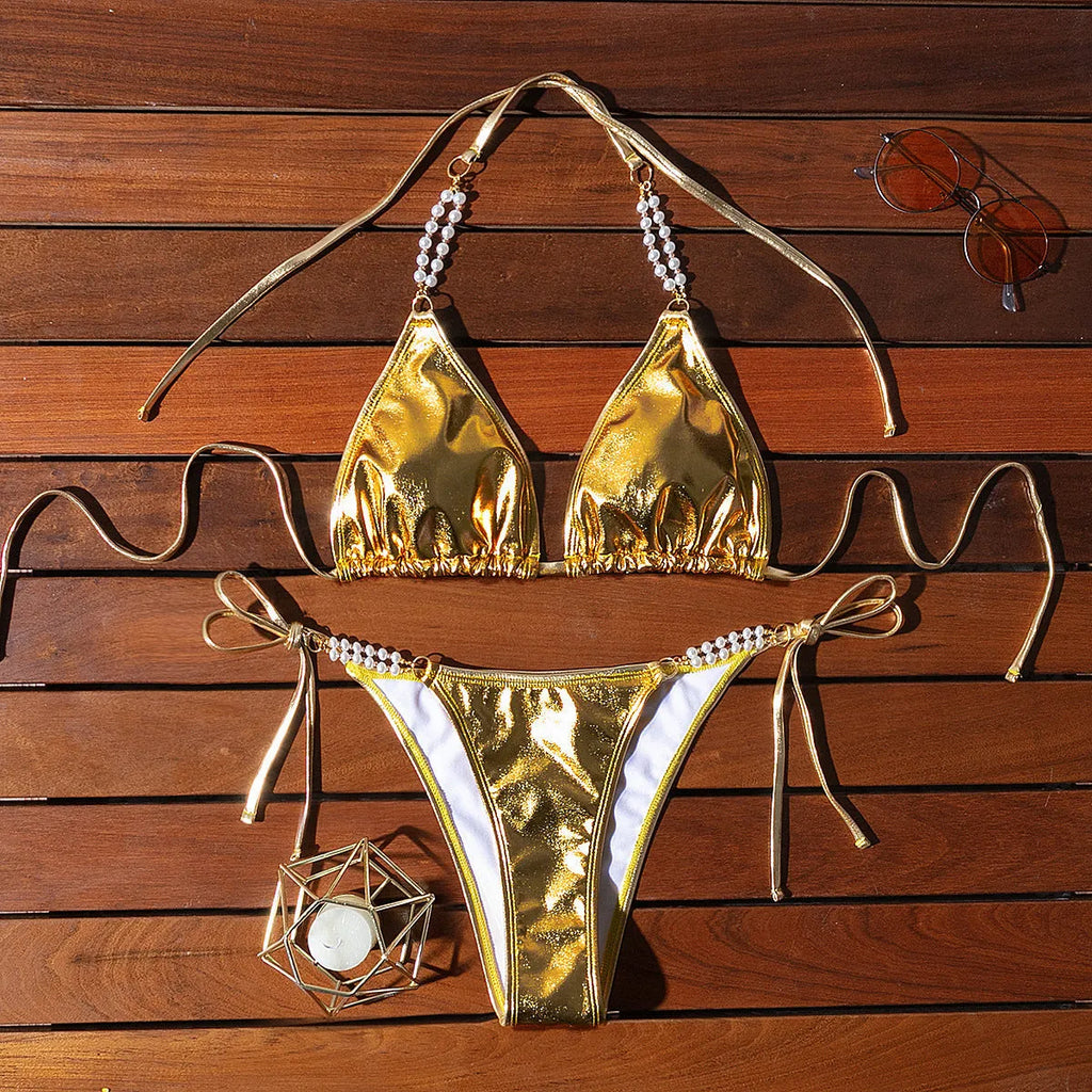 Gold women's halter lace-up bikini swimsuit with pearl chain detailing on mannequin