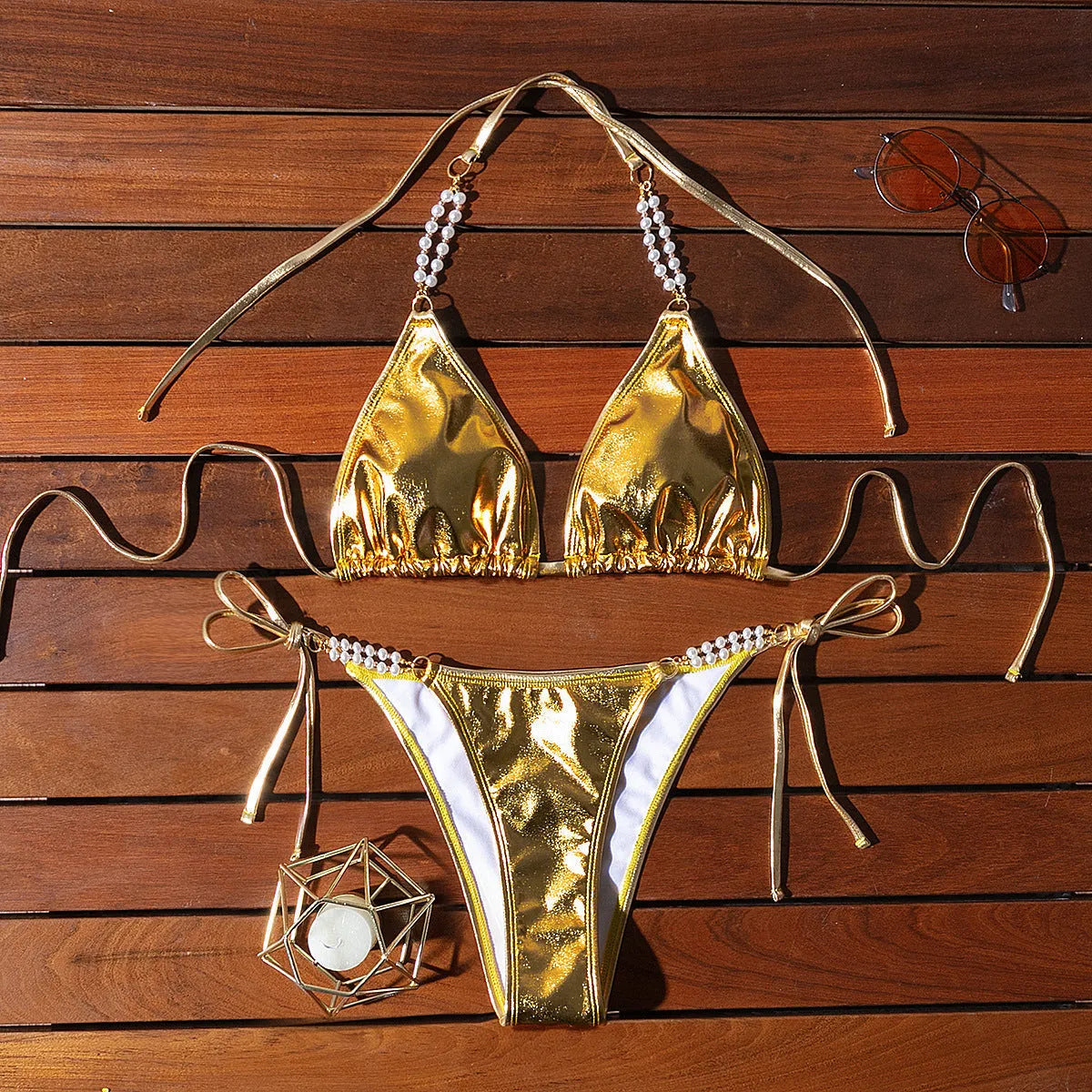 Gold women's halter lace-up bikini swimsuit with pearl chain detailing on mannequin