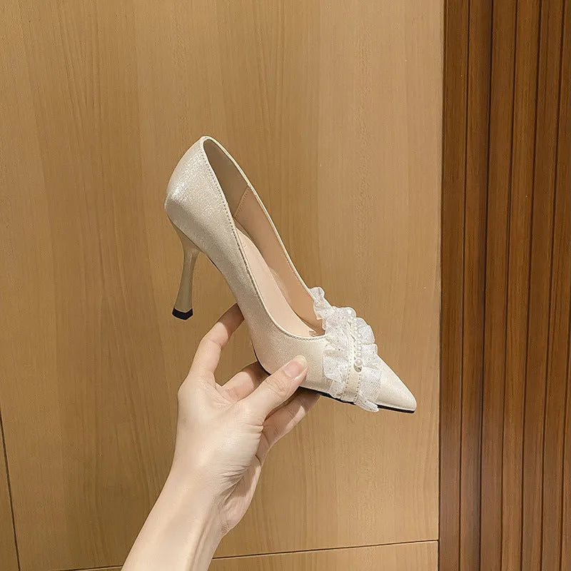 Women's stiletto heels in champagne colour with satin upper, pointed toe, and decorative lace and beading
