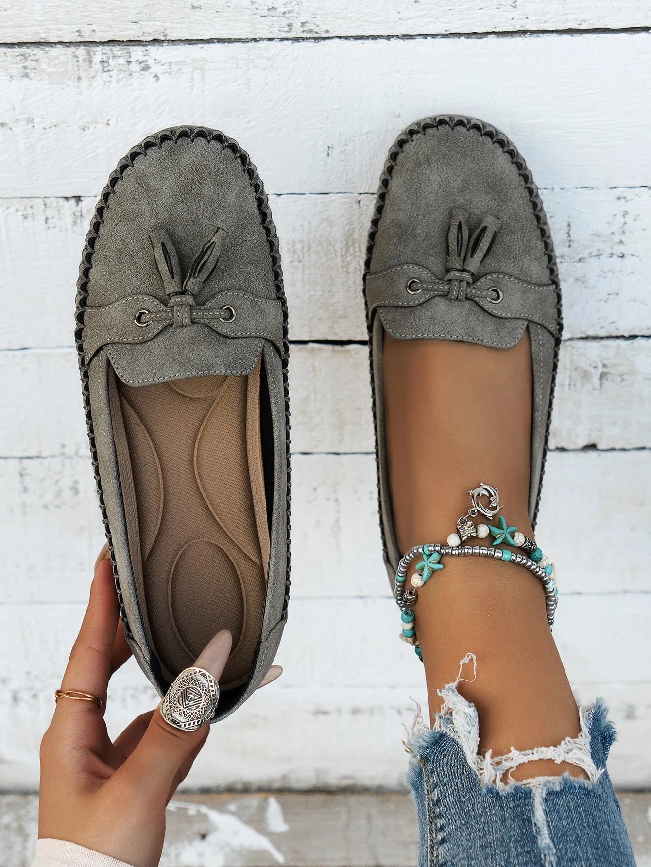 Women's casual suede flat shoes with a bow decoration, shown in a solid colour with a round toe and low heel.