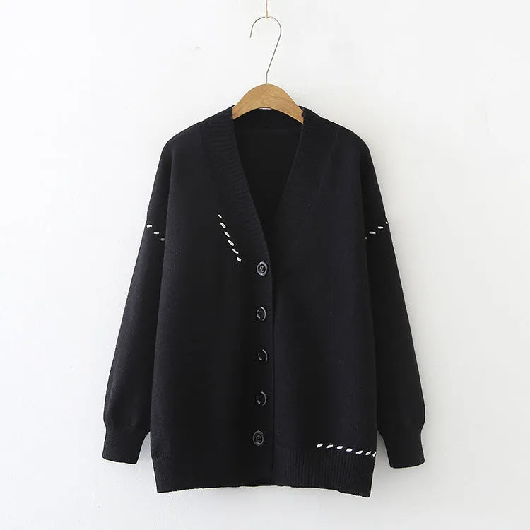 Women's loose black knitted cardigan coat with long sleeves on a hanger