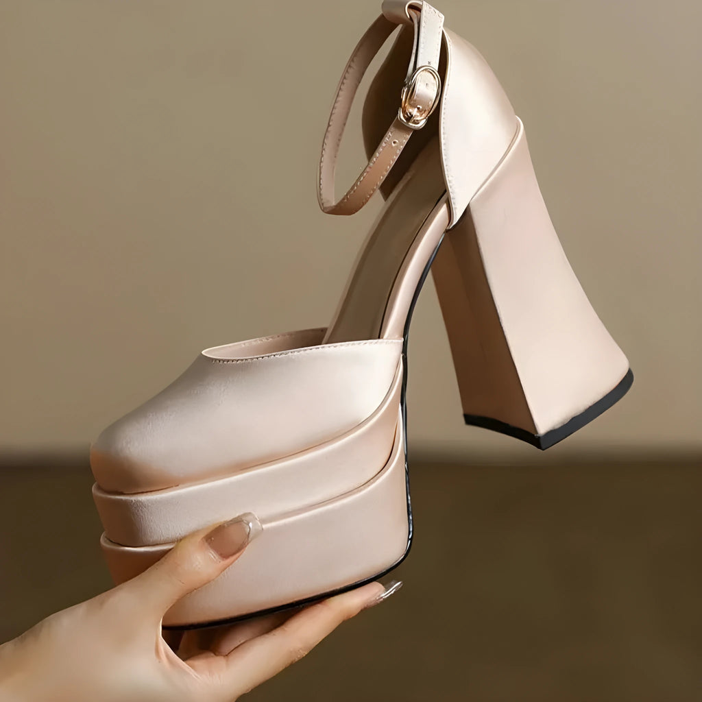 Women's white chunky heel platform pumps with a round toe and ankle strap on a plain background.