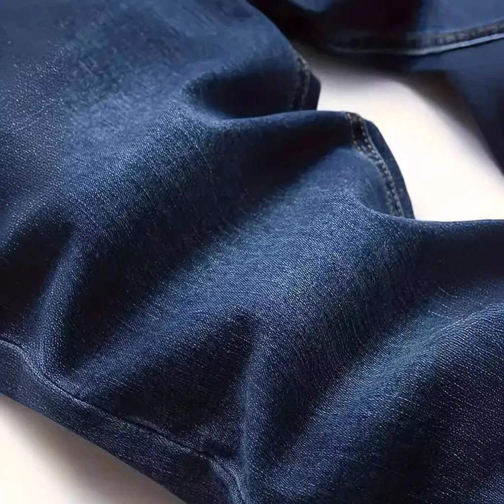 Men's dark blue skinny fit cotton jeans with a mid-rise waist and zipper fly on a plain background.