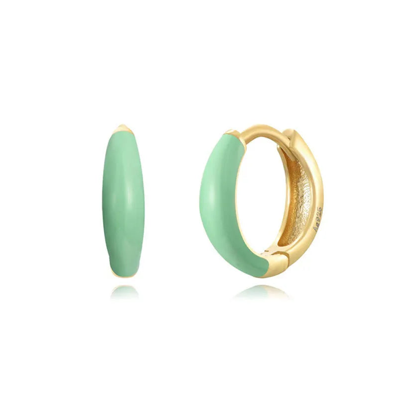 A pair of oval-shaped epoxy resin earrings on a U-shaped curved silver hook, showing a marbled colour finish.