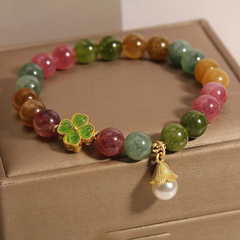 Women's silver-tone bracelet with a drop-shaped four-leaf clover pearl charm and colourful tourmaline stones on a geometric link band.