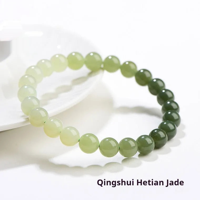 Natural Hetian jade bracelet with gradient clear water colour beads on a wrist.