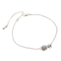 Gold and silver alloy pineapple charm bracelet on wrist, showing adjustable clasp.