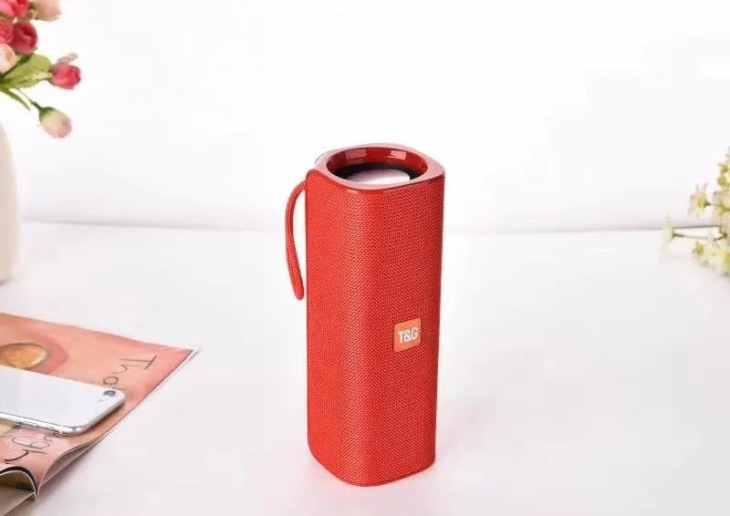 Cloth wireless Bluetooth speaker in multiple colours showing front grill and control buttons.