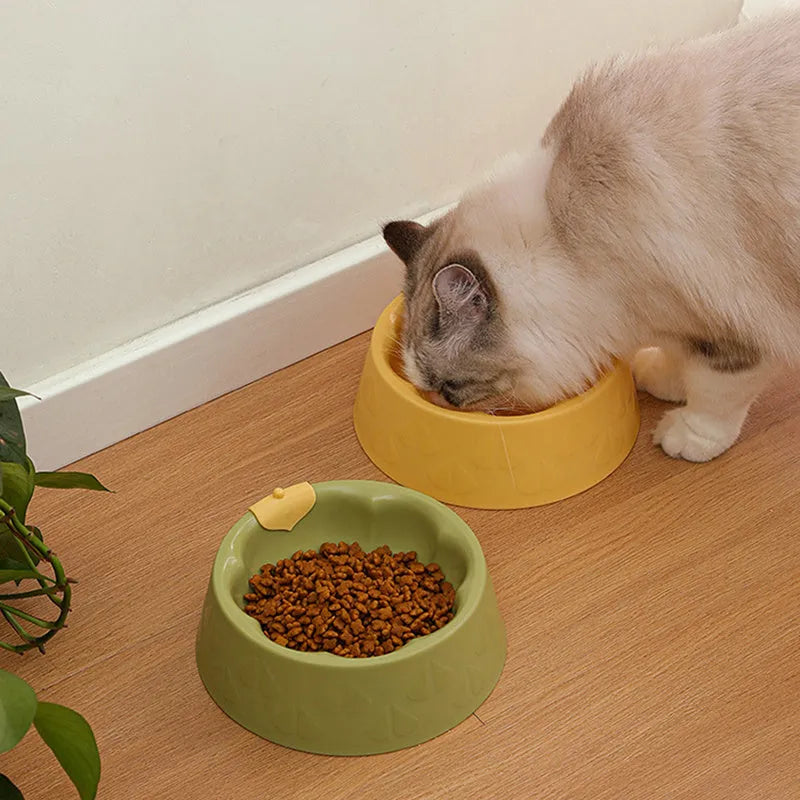 Green flower-shaped plastic double bowl for cat or small dog food and water on a plain surface.
