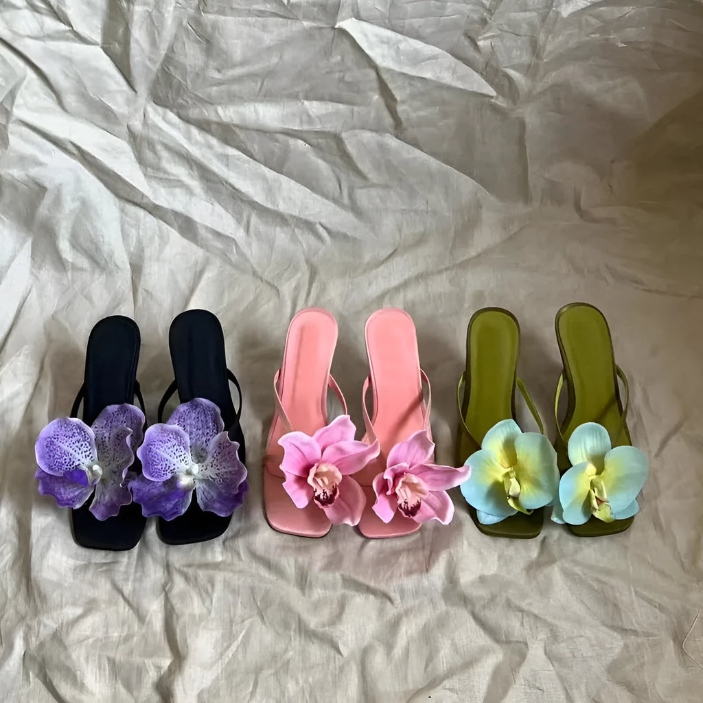 Pink satin women's high heel sandals with a square toe and a white artificial flower decoration.