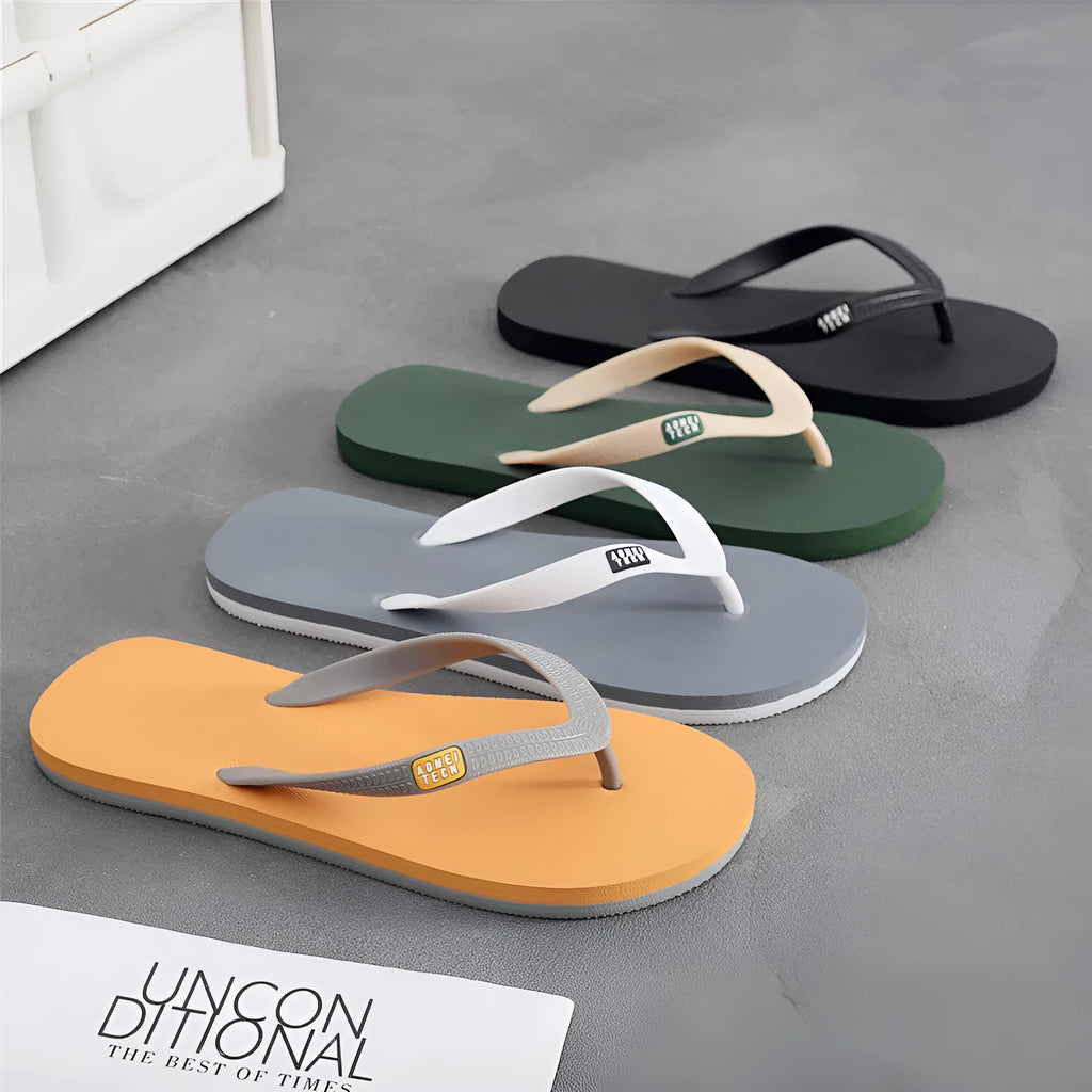 Men's black flip-flops with a textured rubber sole and a lightweight EVA upper on a sandy beach.