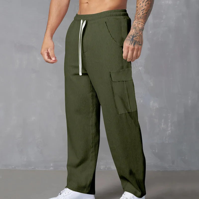 Man wearing navy blue loose-fit corduroy cargo trousers with a drawstring waist.
