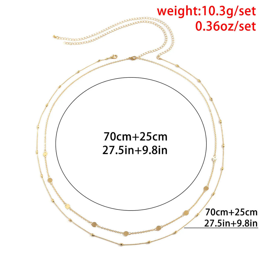 Gold double-layer belly chain with tassel detail and lobster clasp on a white background