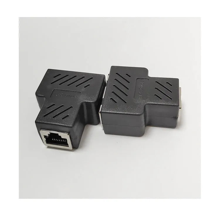 White RJ45 three-way tee network cable splitter adapter on a table.