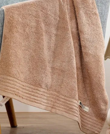 Cotton towel set in brown or beige showing bath sheet, hand towel, and face cloth sizes