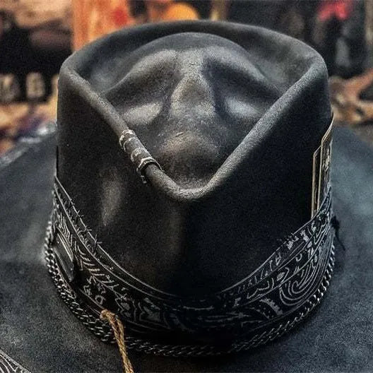 Handmade black wool felt skull hat with conical crown and blue denim accent band, shown from the side.