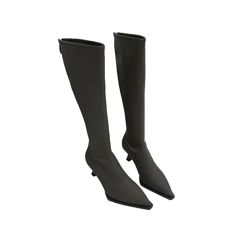 Women's black pointed toe below-the-knee boots with a stiletto heel and back zip on a neutral background.