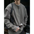 Men's solid grey loose-fit long sleeve pullover top on a hanger.