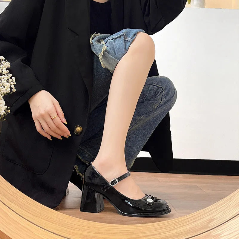 Women's black patent leather wide fit shoes with chunky heel and round toe, showing buckle fastening