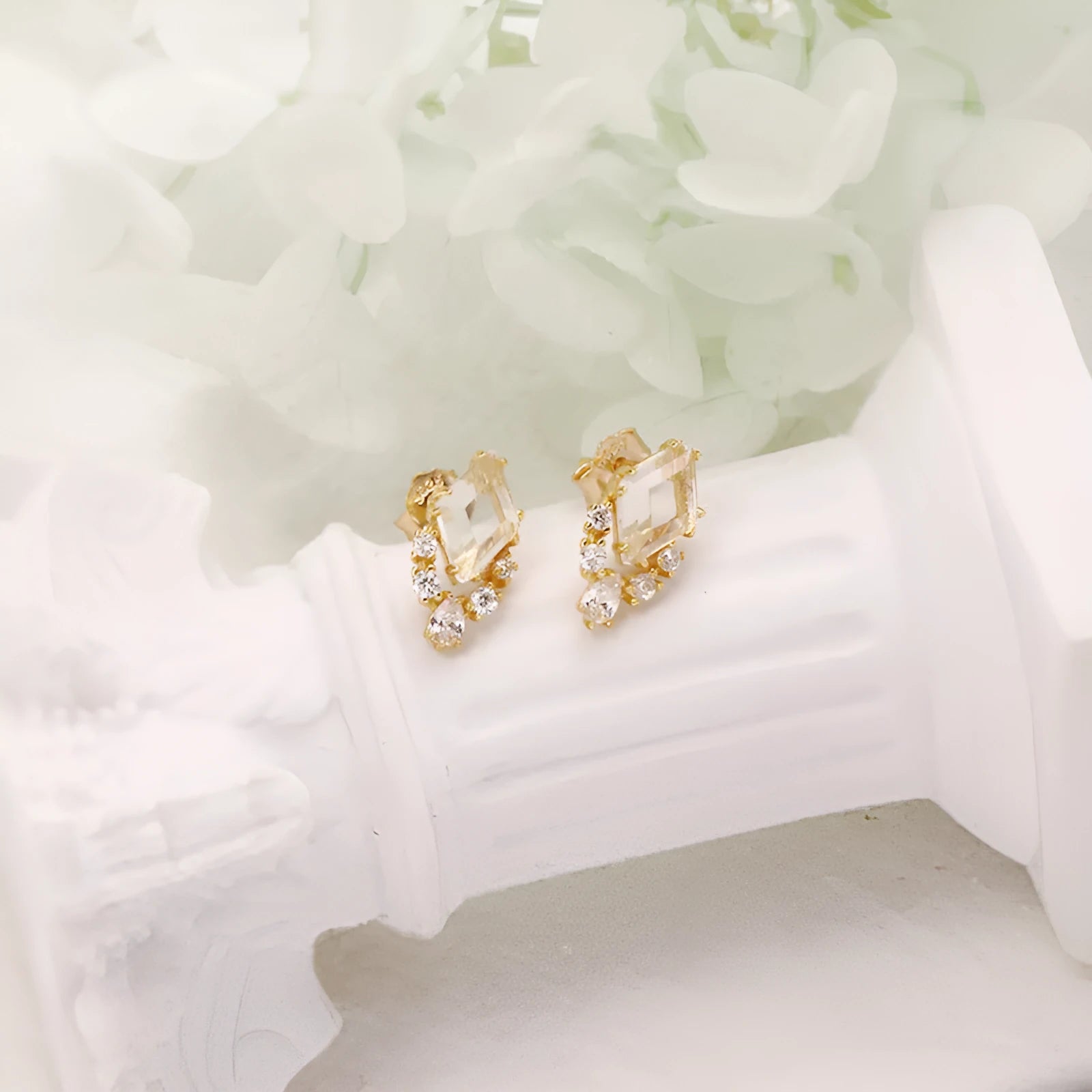 Geometric silver earrings with white crystal studs showing front detail