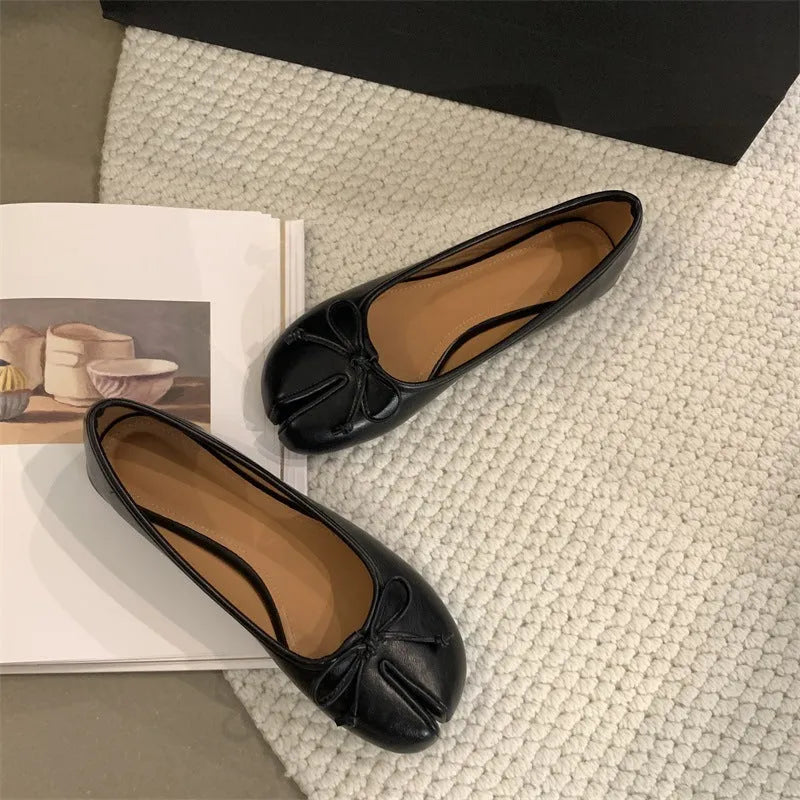 Women's split-toe flat pumps in beige with a round toe and flat rubber sole.