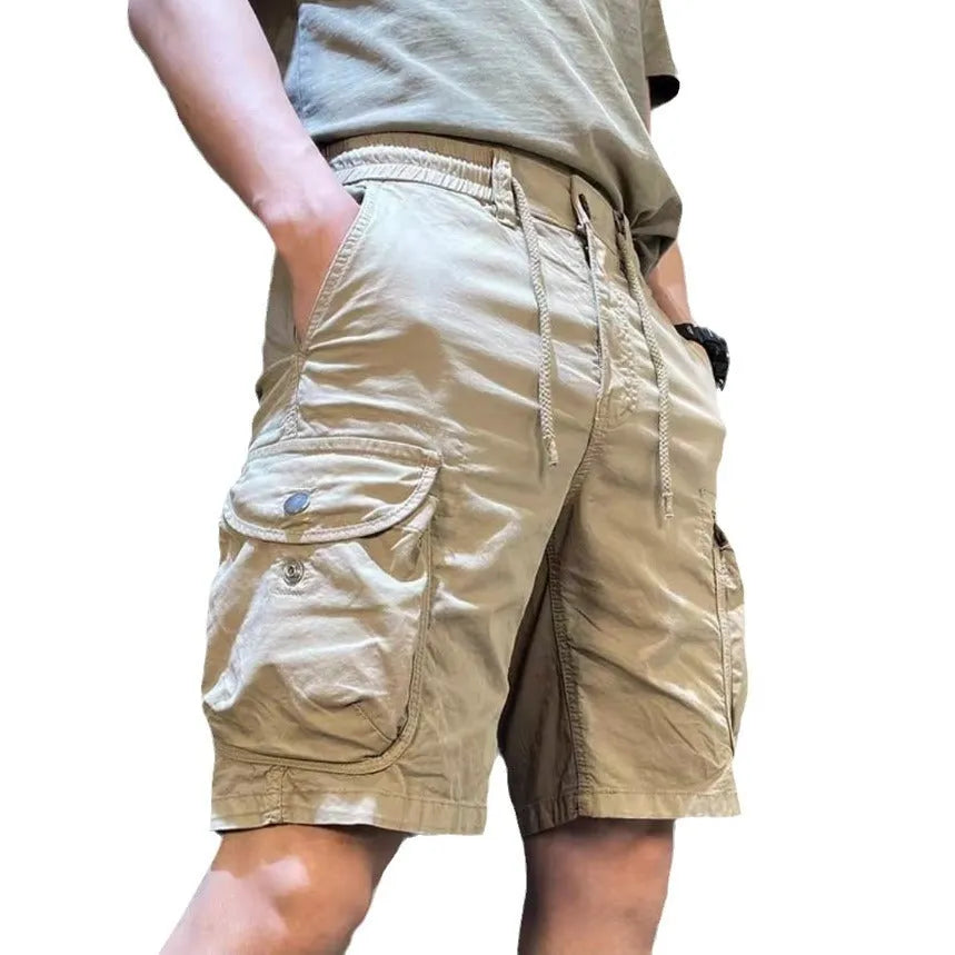 Loose straight-leg khaki overalls trousers with elastic waist and front slash pockets on a neutral background