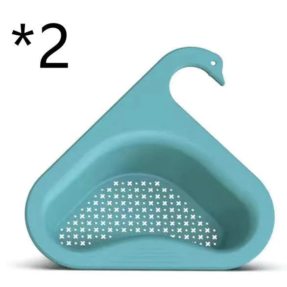Blue plastic swan-shaped basket hanging over a kitchen sink edge to drain fruit and vegetables.