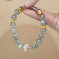 A simple gray moonstone bracelet for women with 8mm round beads on a white background.