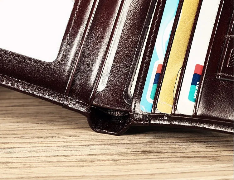 Men's black full-grain leather bifold wallet showing open interior with card slots and an exterior zippered coin pouch.
