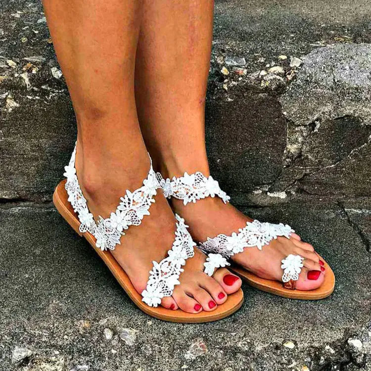 White women's flat sandals with rhinestone floral detail on artificial PU upper