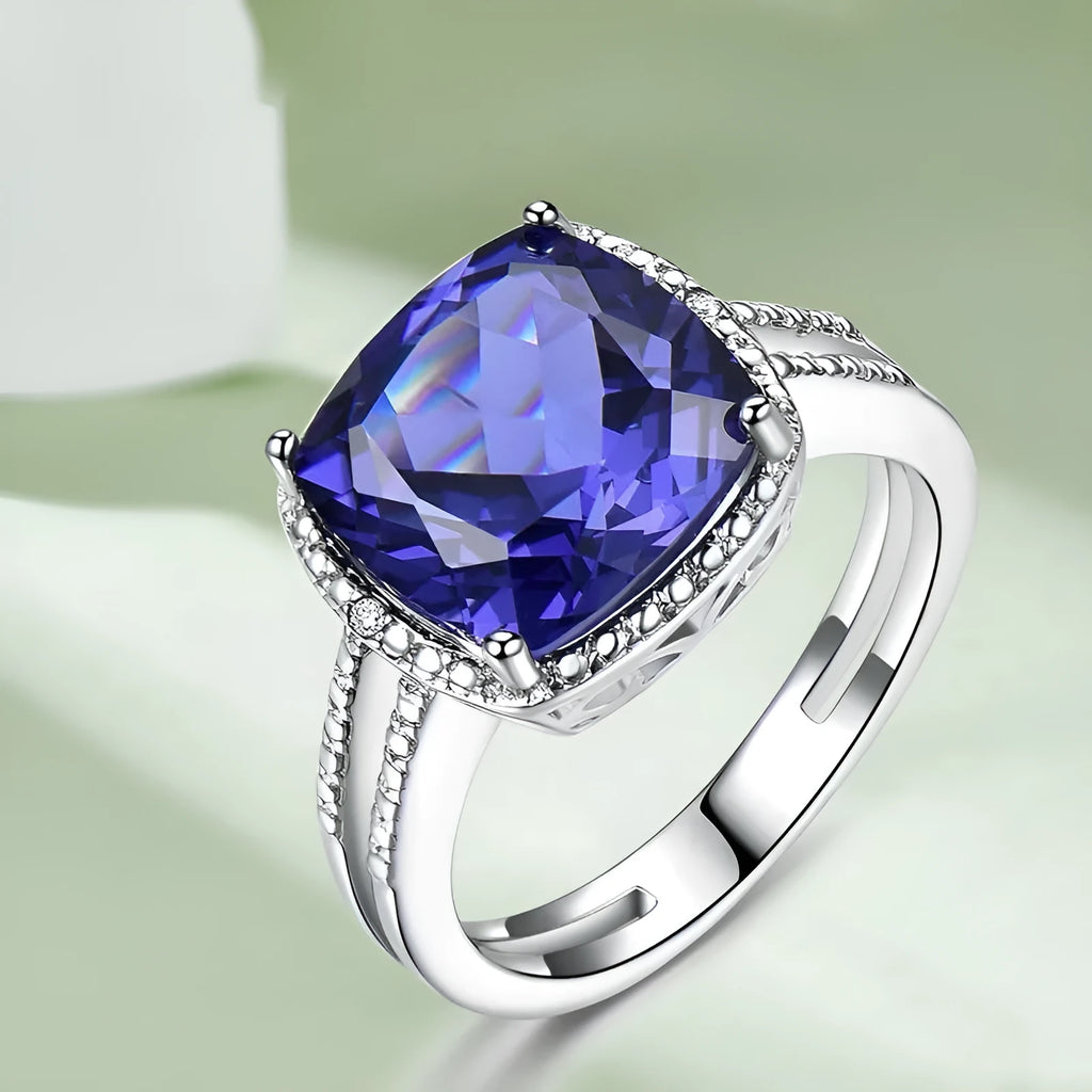 A blue tanzanite stone set in a sterling silver women's ring on a white background.