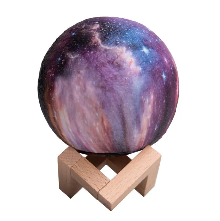 3D-printed spherical lunar night light on a surface, showing its colour-changing LED glow and remote control.