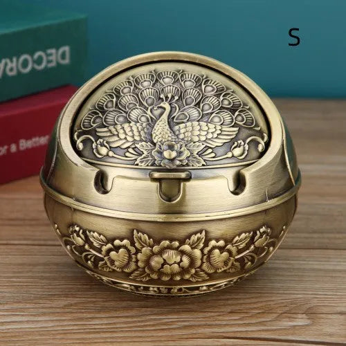 Bronze and red copper alloy decorative ashtray with smoke-extinguishing slot on a table.