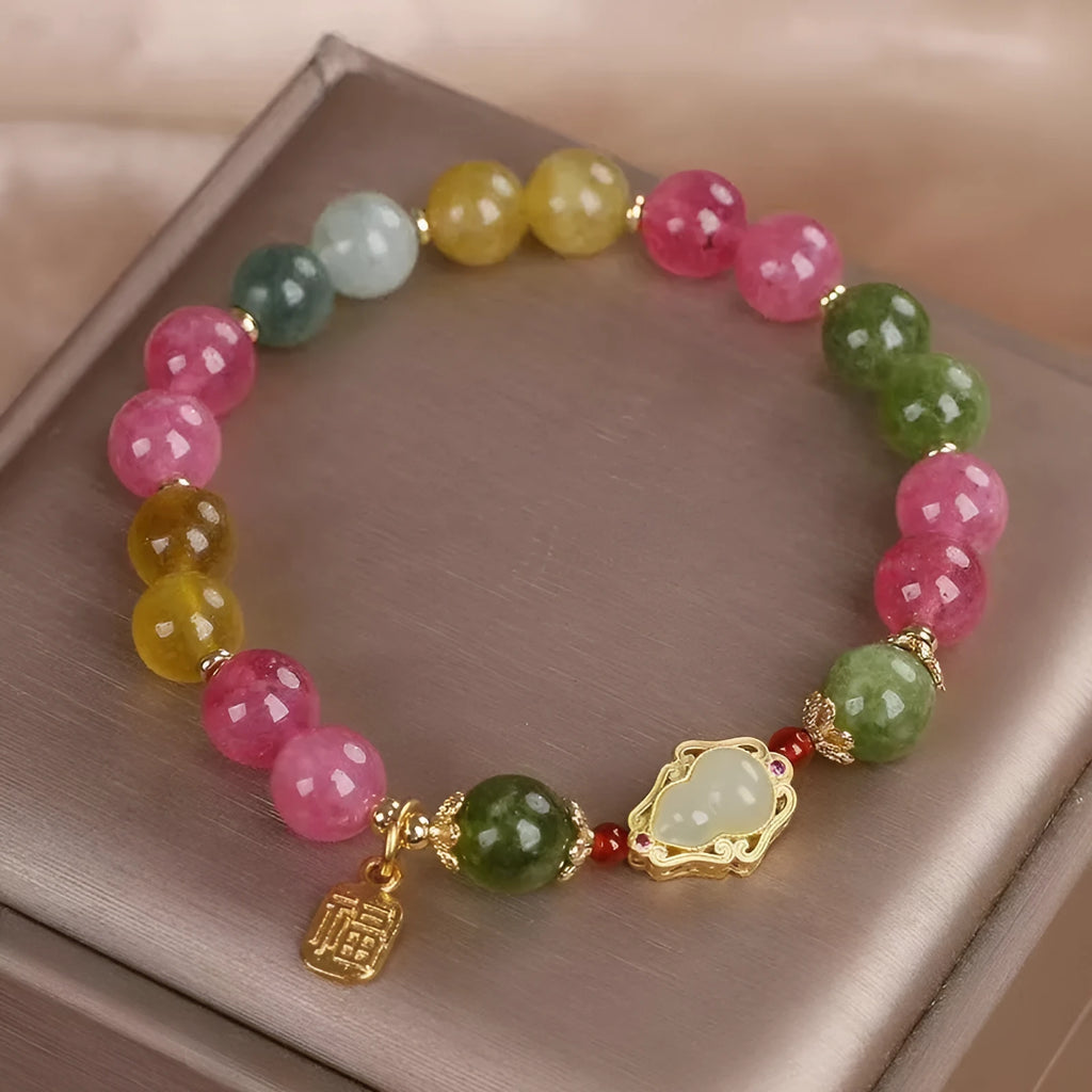 Close-up of a women's gourd blessing card bracelet with colourful tourmaline stones and electroplated finish.