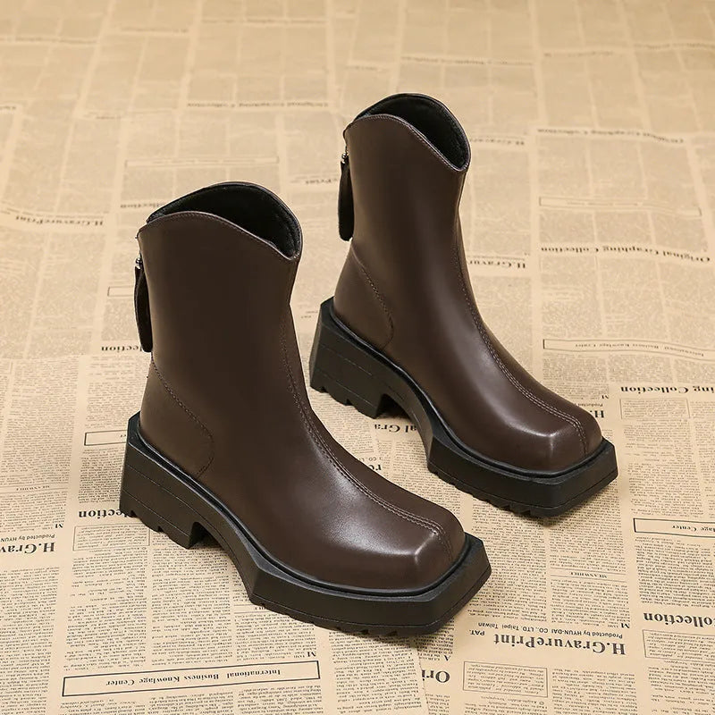 Women's black platform Martin boots with a square toe, chunky sole, and rear zip fastener