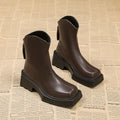 Women's black platform Martin boots with a square toe, chunky sole, and rear zip fastener