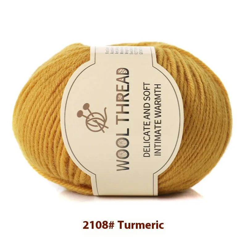 One roll of beige domestic wool hand-knitting yarn for size 10 needles next to knitting needles.