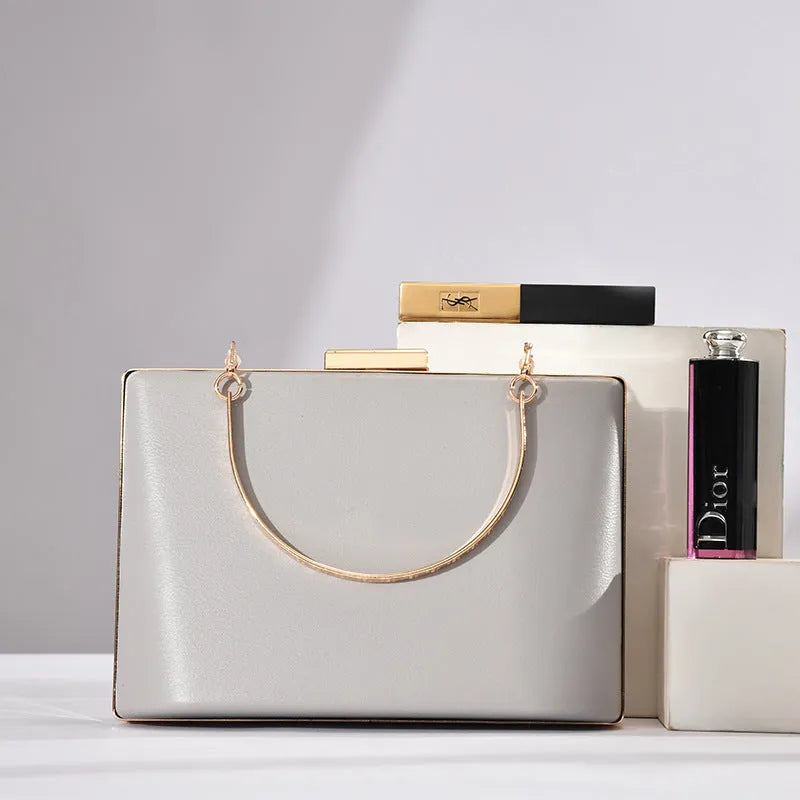 Solid colour PU leather crossbody bag in pillow shape with double-ring detail, 18.5x13.5x7cm, in black.