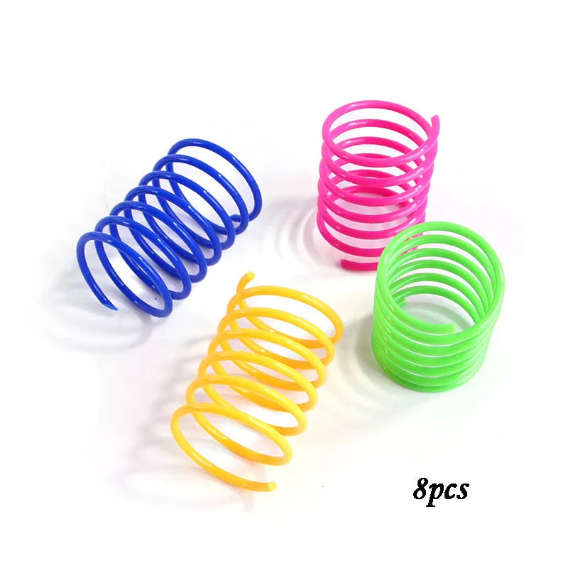 Colourful plastic coil spring toys for cats on a wooden floor.