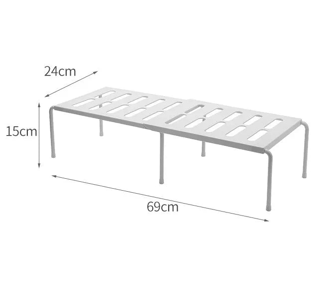 White telescopic plastic storage rack extended to full height with kitchen utensils organised on shelf