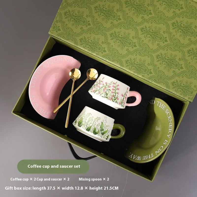 Ceramic coffee cup and saucer set with two cups, two plates, and two spoons