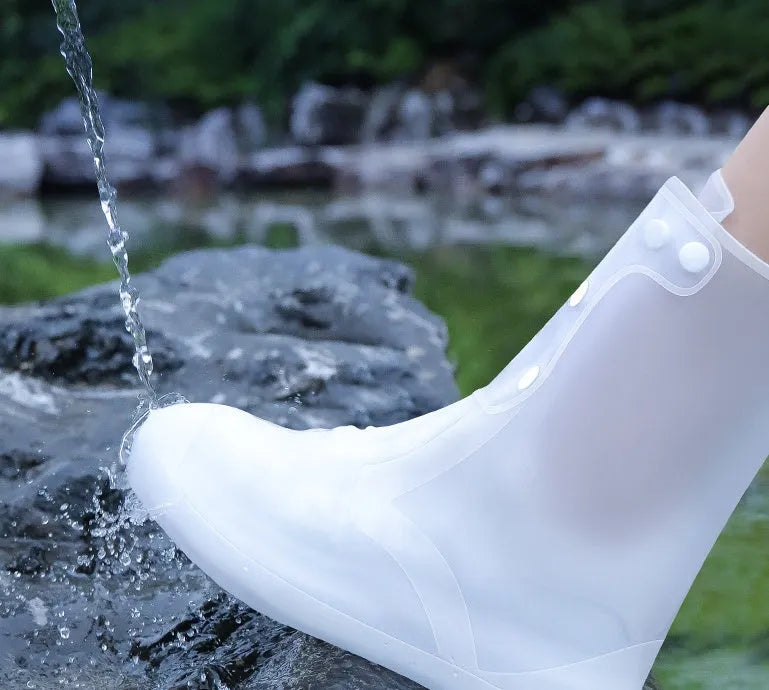 White high-top PVC reusable shoe covers for women, shown on feet.