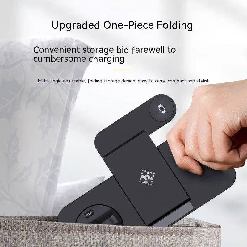 Black six-in-one foldable wireless charger with phone, earbuds, and watch charging zones on a desk