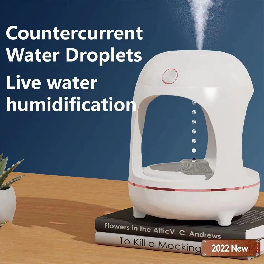Rose gold and white columnar humidifier with levitating water drops and LED lighting on desk