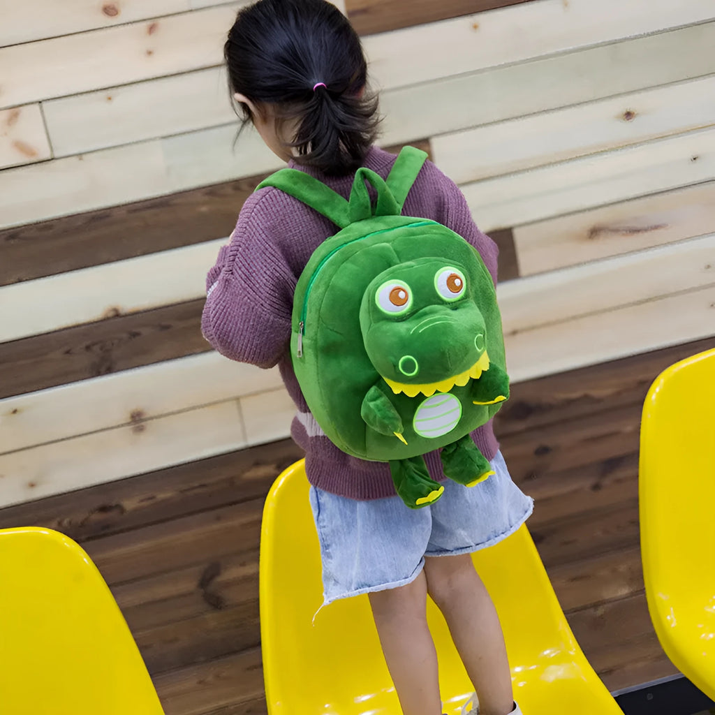 Soft blue plush children's backpack with an embroidered dinosaur character and a soft handle.