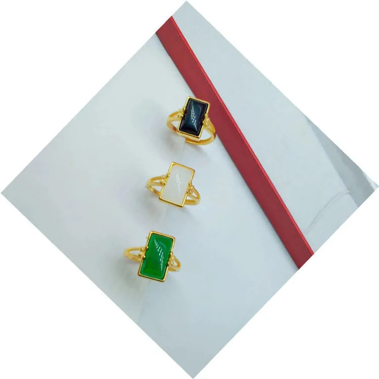Gold-plated brass ring with an adjustable band and a central green gemstone in a national style.