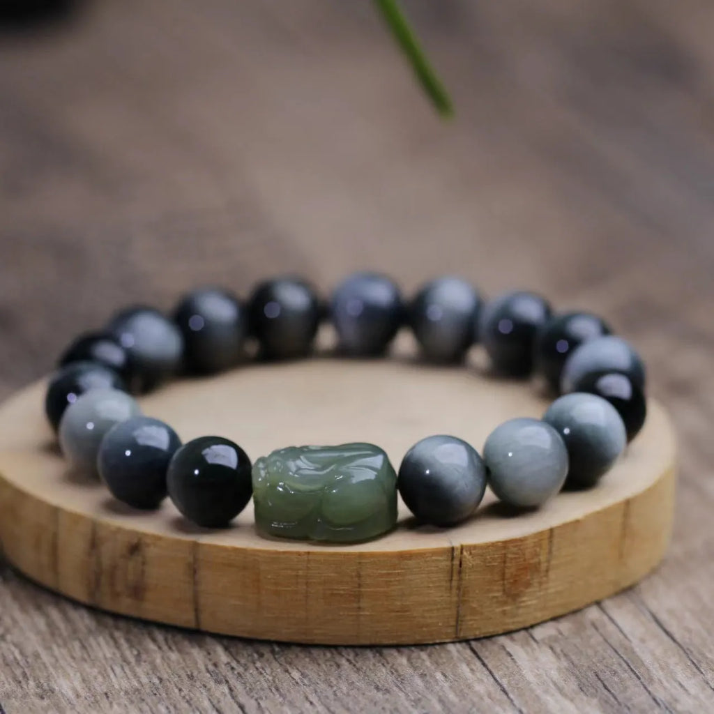 Black bracelet with 10mm Eagle Eye stone beads and a Hetian Jade Pixiu charm.
