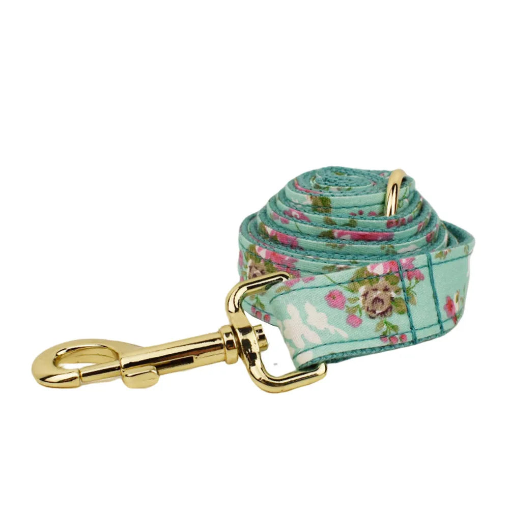 Four-piece dog accessory set with rose print bow, green fabric collar, leash and vest