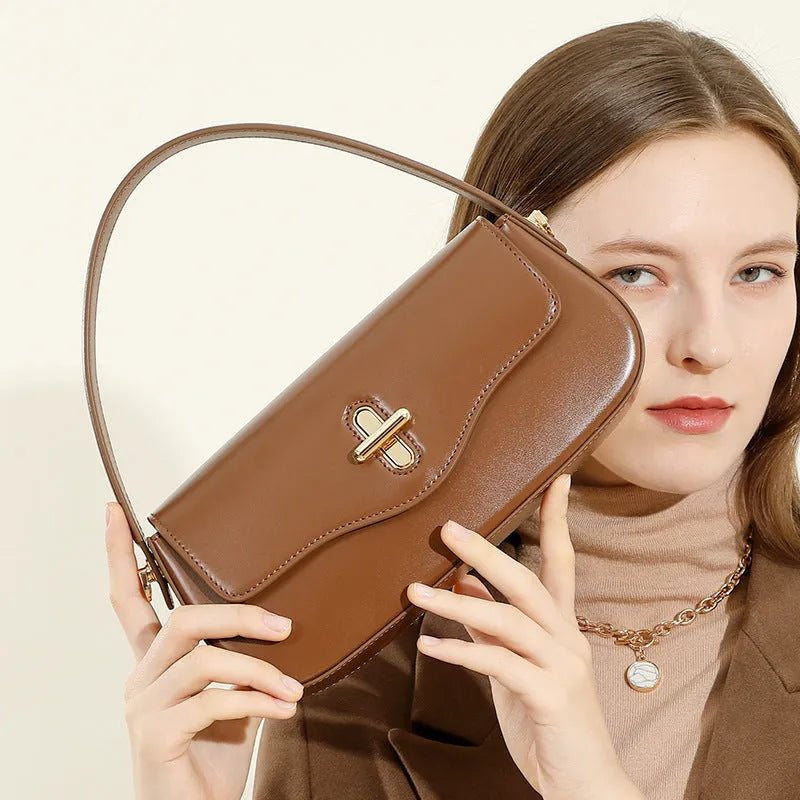 Genuine leather women's baguette handbag with lock detail and double shoulder straps