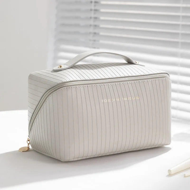 Vertical pattern pillow-shaped cubic makeup bag in PU material for women's travel storage.